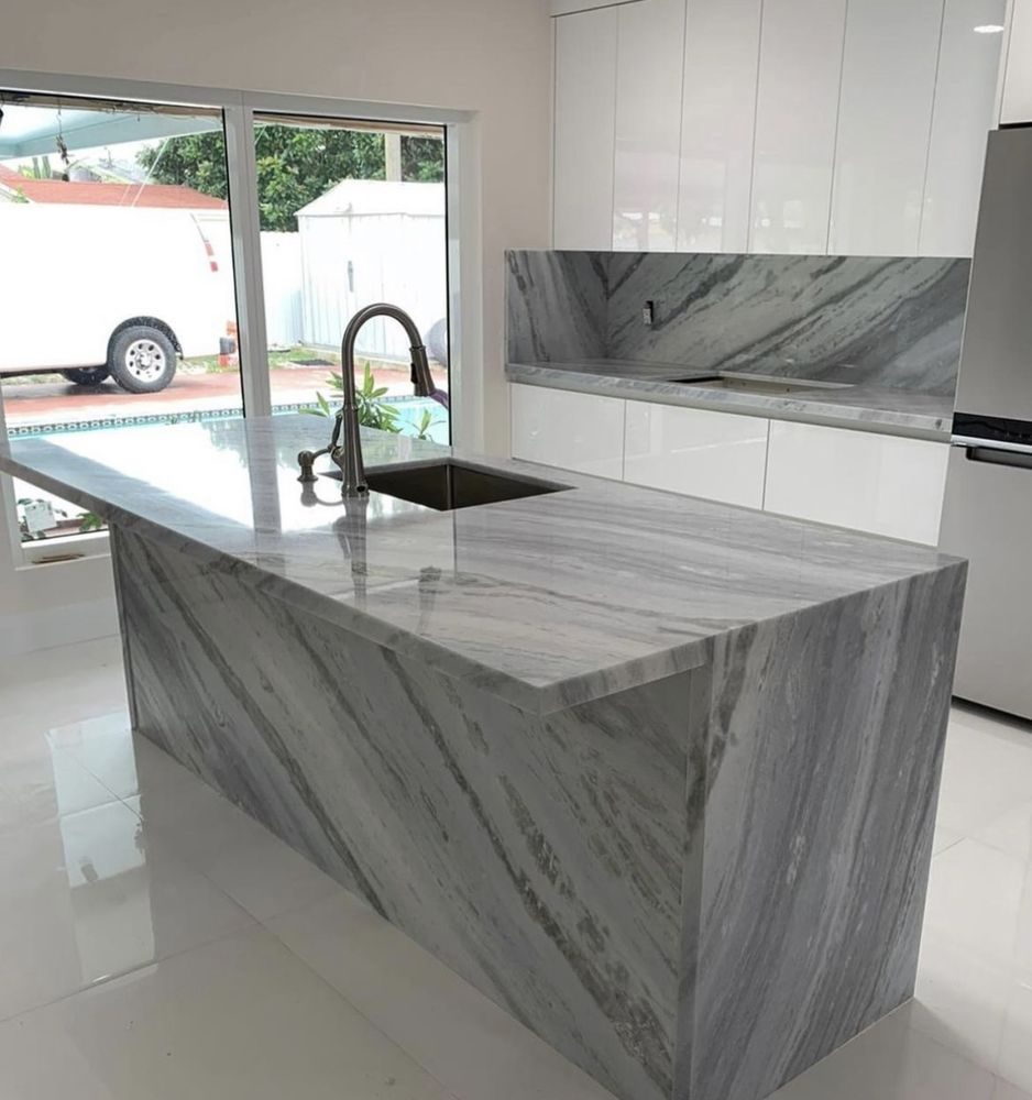 Kitchen island and full backsplash in grey veined natural stone by Roman Stone Surfaces, Miami