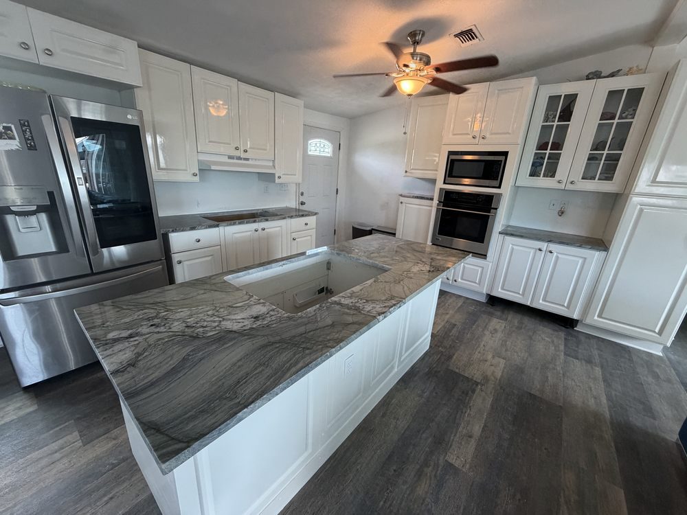 White kitchen with a large veined natural-stone island