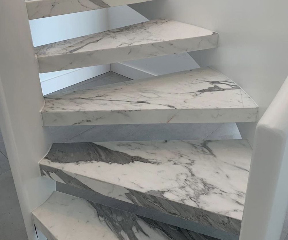 Floating staircase clad in veined white marble